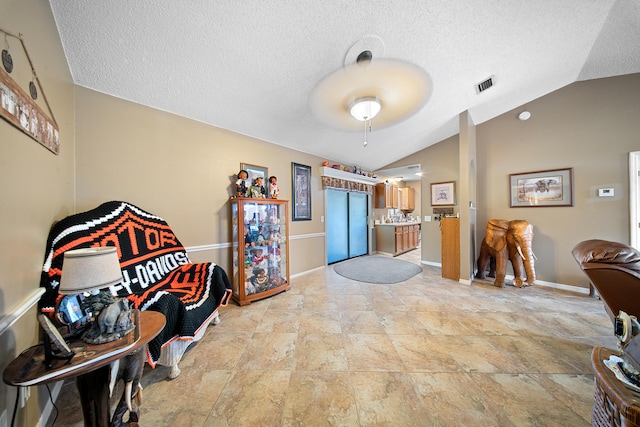 7201 N Blvd, Fort Pierce, FL 34951 - foyer featuring vaulted ceiling, a textured ceiling, light stone finish floors, and baseboards