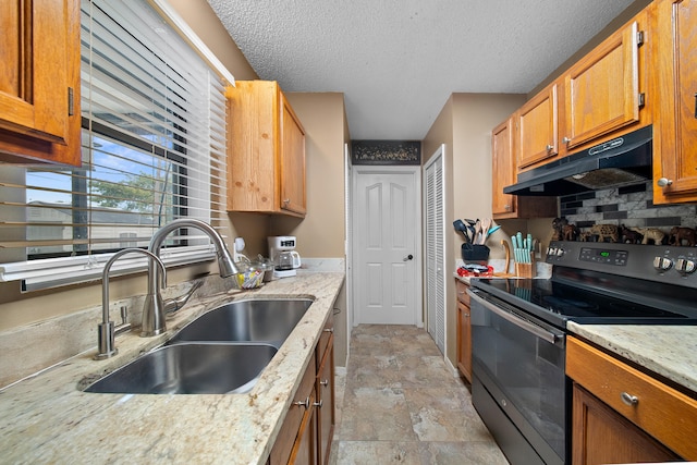 7201 N Blvd, Fort Pierce, FL 34951 - kitchen with black electric range oven, under cabinet range hood, a sink, a textured ceiling, and light stone countertops