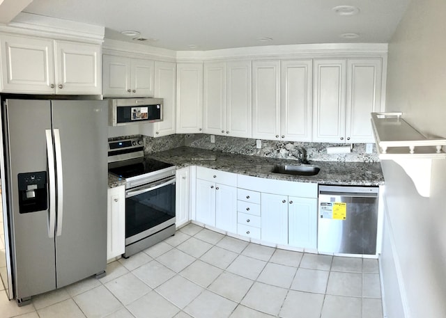 3026 Lincoln B 3026, Boca Raton, FL 33434 - kitchen with stainless steel appliances, a sink, white cabinetry, light tile patterned floors, and dark stone countertops