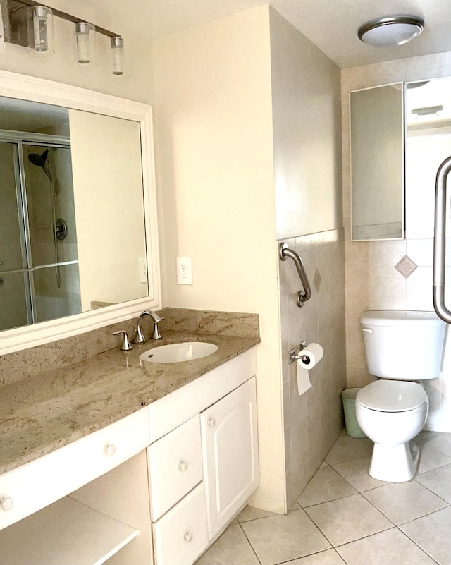 3026 Lincoln B 3026, Boca Raton, FL 33434 - bathroom featuring tile patterned floors, toilet, vanity, an enclosed shower, and tile walls