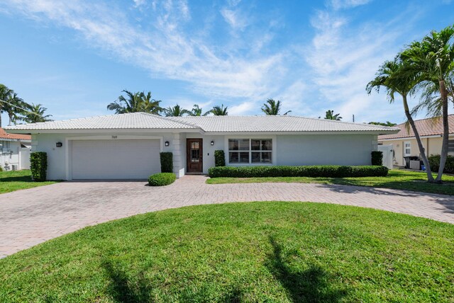769 Berkeley St, Boca Raton, FL 33487 - ranch-style home featuring an attached garage, stucco siding, decorative driveway, a front yard, and a tiled roof