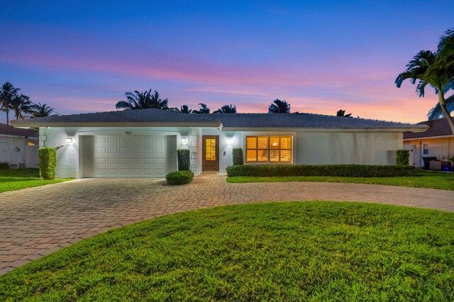 769 Berkeley St, Boca Raton, FL 33487 - ranch-style house featuring curved driveway, an attached garage, stucco siding, and a front yard