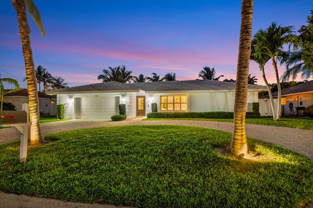 769 Berkeley St, Boca Raton, FL 33487 - view of front of property with curved driveway, a yard, a garage, and stucco siding