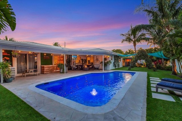 769 Berkeley St, Boca Raton, FL 33487 - pool at dusk with a patio area, a yard, an outdoor pool, and an outdoor living space