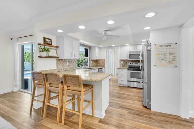 769 Berkeley St, Boca Raton, FL 33487 - kitchen featuring stainless steel appliances, a peninsula, crown molding, open shelves, and recessed lighting