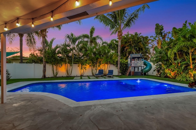 769 Berkeley St, Boca Raton, FL 33487 - pool at dusk featuring a patio area and a playground
