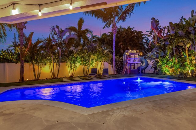 769 Berkeley St, Boca Raton, FL 33487 - pool at dusk with a fenced backyard and a patio
