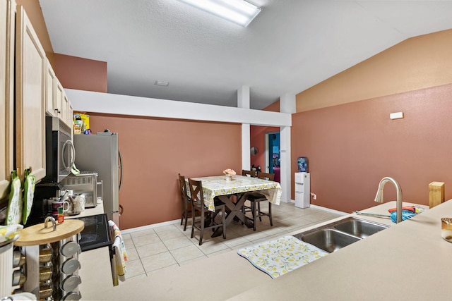 3182 SW Cathedral St, Port Saint Lucie, FL 34953 - kitchen with stainless steel microwave, lofted ceiling, light tile patterned floors, a sink, and light countertops