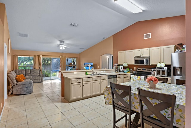 3182 SW Cathedral St, Port Saint Lucie, FL 34953 - kitchen featuring stainless steel appliances, a peninsula, vaulted ceiling, arched walkways, and open floor plan