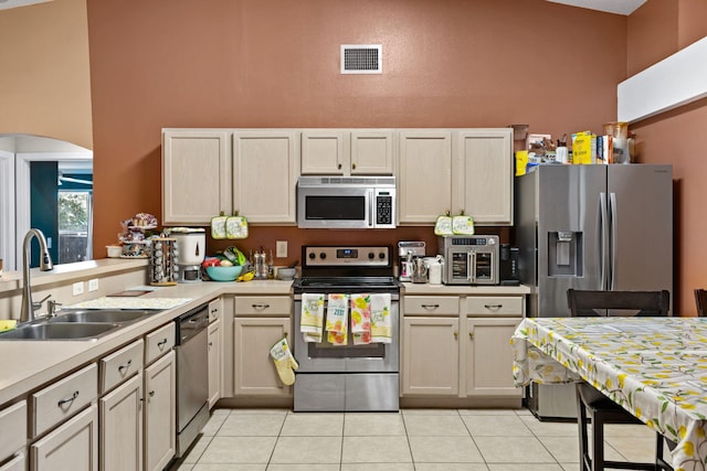 3182 SW Cathedral St, Port Saint Lucie, FL 34953 - kitchen with appliances with stainless steel finishes, a sink, light countertops, light tile patterned flooring, and a high ceiling
