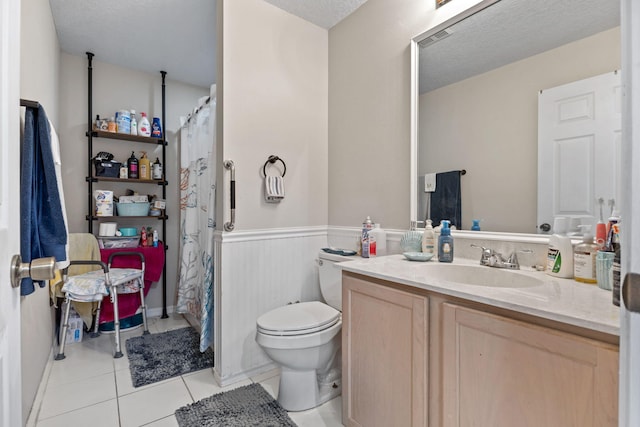 3182 SW Cathedral St, Port Saint Lucie, FL 34953 - bathroom with vanity, toilet, tile patterned flooring, wainscoting, and curtained shower