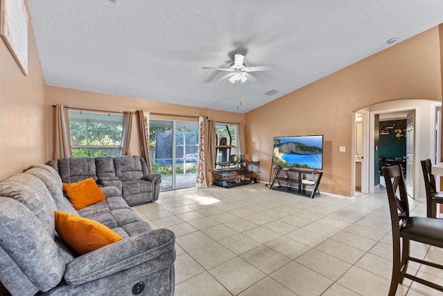 3182 SW Cathedral St, Port Saint Lucie, FL 34953 - living area with vaulted ceiling, light tile patterned floors, a ceiling fan, plenty of natural light, and arched walkways