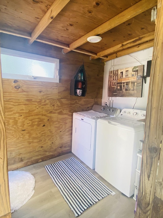 3093 SW Berry Ave, Palm City, FL 34990 - laundry area with washing machine and clothes dryer, wood ceiling, wooden walls, and light wood-style floors
