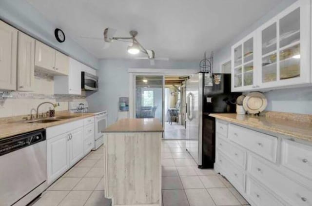3093 SW Berry Ave, Palm City, FL 34990 - kitchen featuring stainless steel appliances, a kitchen island, a sink, glass insert cabinets, and a ceiling fan