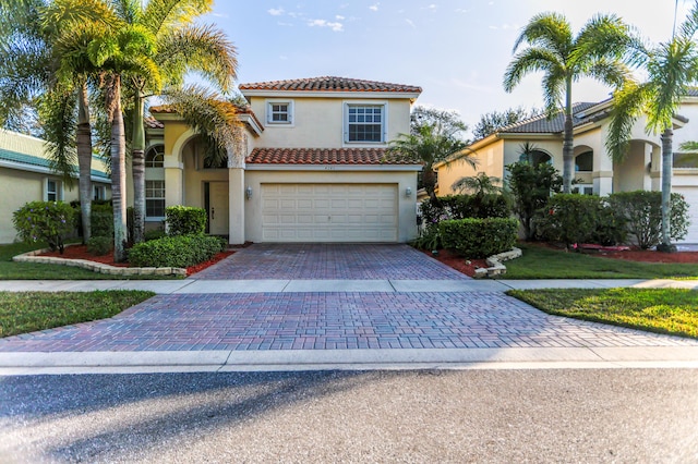 4245 Bluff Harbor Way, Wellington, FL 33449 - mediterranean / spanish-style house featuring stucco siding, decorative driveway, an attached garage, and a tile roof