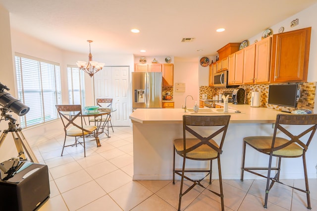 4245 Bluff Harbor Way, Wellington, FL 33449 - kitchen with appliances with stainless steel finishes, a peninsula, light countertops, tasteful backsplash, and a chandelier