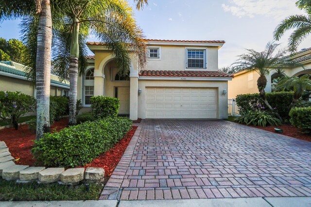 4245 Bluff Harbor Way, Wellington, FL 33449 - mediterranean / spanish-style home featuring stucco siding, a tile roof, a garage, and decorative driveway