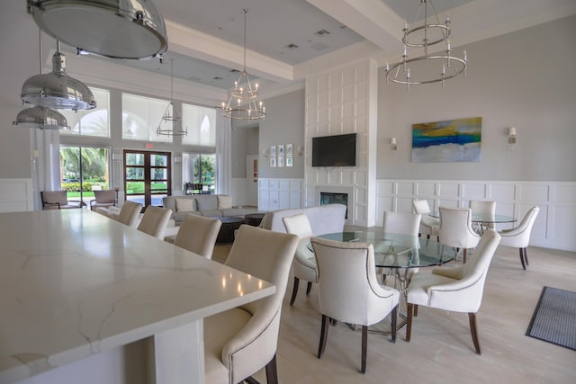 4245 Bluff Harbor Way, Wellington, FL 33449 - dining room featuring a chandelier, a towering ceiling, a large fireplace, a decorative wall, and crown molding