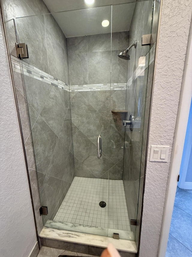 478 Capri J, Delray Beach, FL 33484 - bathroom featuring a shower stall, tile patterned flooring, a textured wall, and recessed lighting
