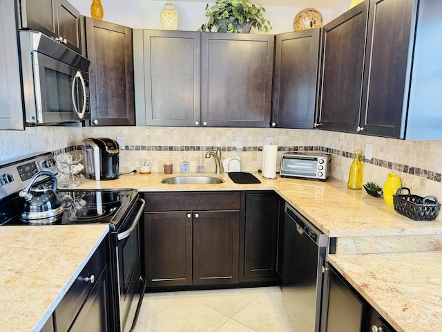 478 Capri J, Delray Beach, FL 33484 - kitchen featuring appliances with stainless steel finishes, a sink, light tile patterned floors, tasteful backsplash, and dark brown cabinets