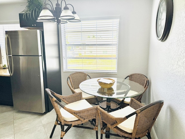 478 Capri J, Delray Beach, FL 33484 - dining space with a textured wall, a chandelier, and light tile patterned floors