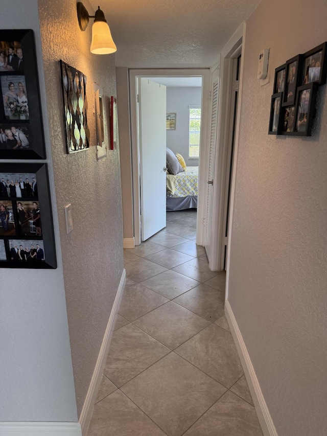 478 Capri J, Delray Beach, FL 33484 - corridor featuring a textured wall, tile patterned floors, and baseboards