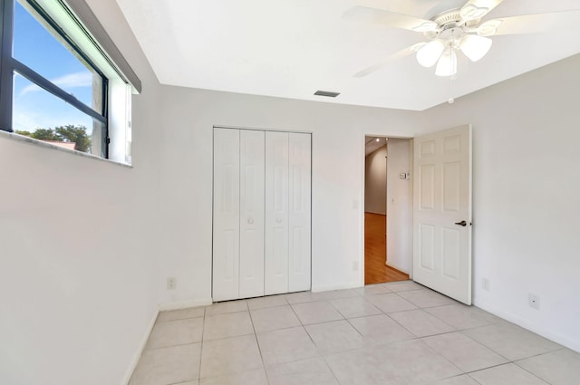 7644 Lexington Club Blvd Unit A, Delray Beach, FL 33446 - unfurnished bedroom with baseboards, light tile patterned flooring, a closet, and a ceiling fan