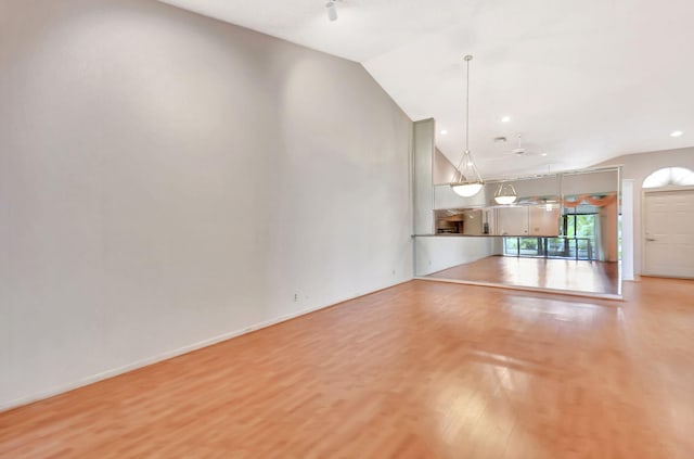 7644 Lexington Club Blvd Unit A, Delray Beach, FL 33446 - unfurnished living room featuring wood finished floors, lofted ceiling, a ceiling fan, baseboards, and recessed lighting