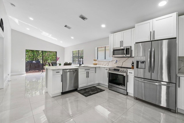 12350 Sand Wedge Dr, Boynton Beach, FL 33437 - kitchen with stainless steel appliances, vaulted ceiling, a sink, light countertops, and decorative backsplash
