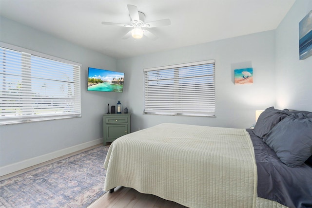 2948 SE Treasure Island Rd, Port Saint Lucie, FL 34952 - bedroom featuring baseboards, wood finished floors, and ceiling fan