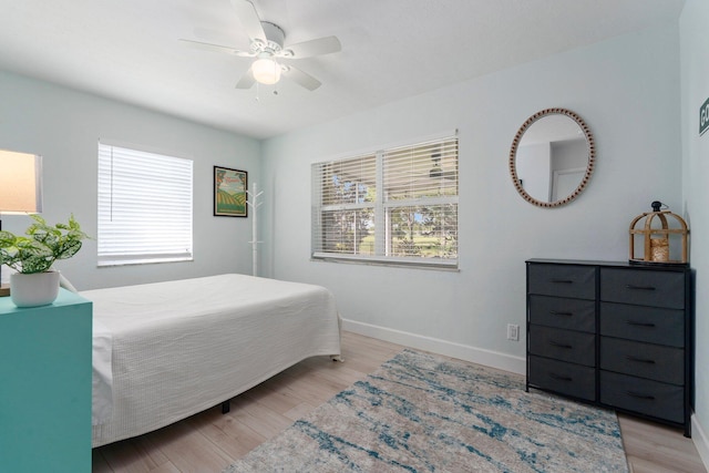 2948 SE Treasure Island Rd, Port Saint Lucie, FL 34952 - bedroom with baseboards, light wood-type flooring, and ceiling fan