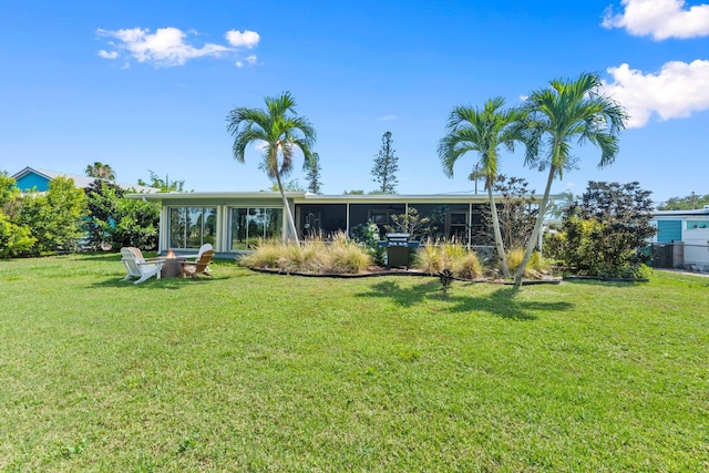 2948 SE Treasure Island Rd, Port Saint Lucie, FL 34952 - back of property with a sunroom and a lawn