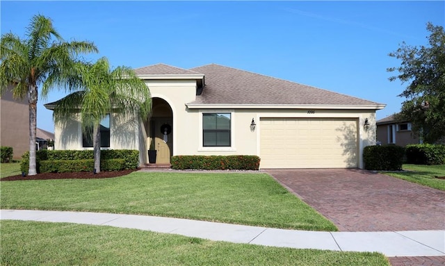 1095 N Verona Trace Dr, Vero Beach, FL 32966 - view of front of house with decorative driveway, an attached garage, stucco siding, a front lawn, and roof with shingles