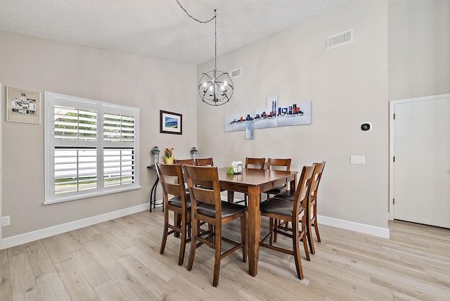 407 SE Duff Ct, Port Saint Lucie, FL 34984 - dining area with a chandelier, light wood-style flooring, and baseboards