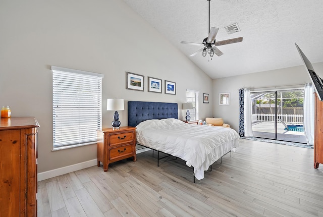 407 SE Duff Ct, Port Saint Lucie, FL 34984 - bedroom featuring access to exterior, light wood-type flooring, high vaulted ceiling, baseboards, and a textured ceiling