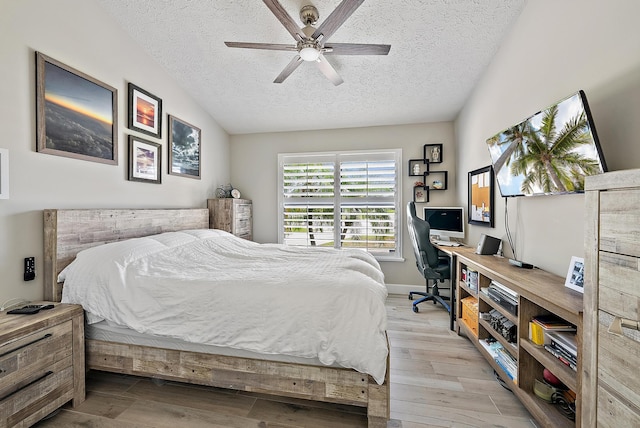 407 SE Duff Ct, Port Saint Lucie, FL 34984 - bedroom featuring a textured ceiling, light wood-style flooring, vaulted ceiling, a ceiling fan, and baseboards