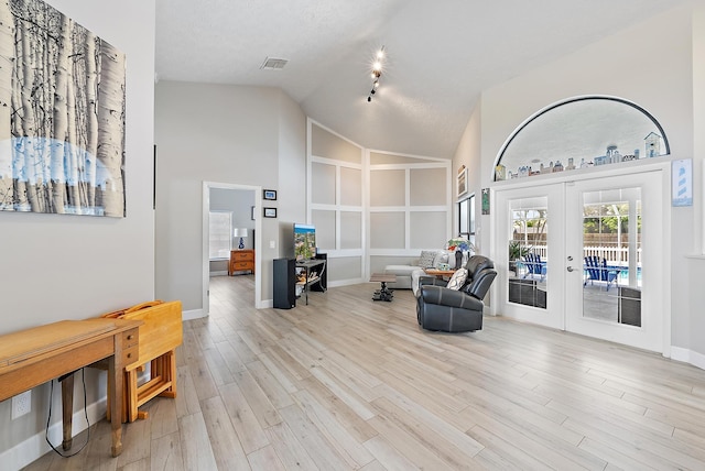 407 SE Duff Ct, Port Saint Lucie, FL 34984 - living area featuring french doors, high vaulted ceiling, light wood-style flooring, baseboards, and built in features