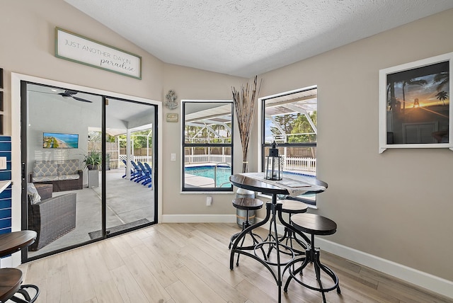 407 SE Duff Ct, Port Saint Lucie, FL 34984 - dining room with light wood finished floors, a sunroom, baseboards, a textured ceiling, and ceiling fan