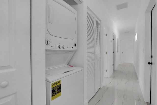 2921 Saginaw Ave Unit 1, West Palm Beach, FL 33417 - laundry room featuring stacked washing machine and dryer and light marble finish floors