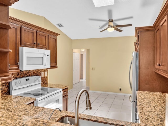 18458 Via Di Sorrento, Boca Raton, FL 33496 - kitchen featuring white appliances, brown cabinetry, a ceiling fan, light tile patterned floors, and vaulted ceiling