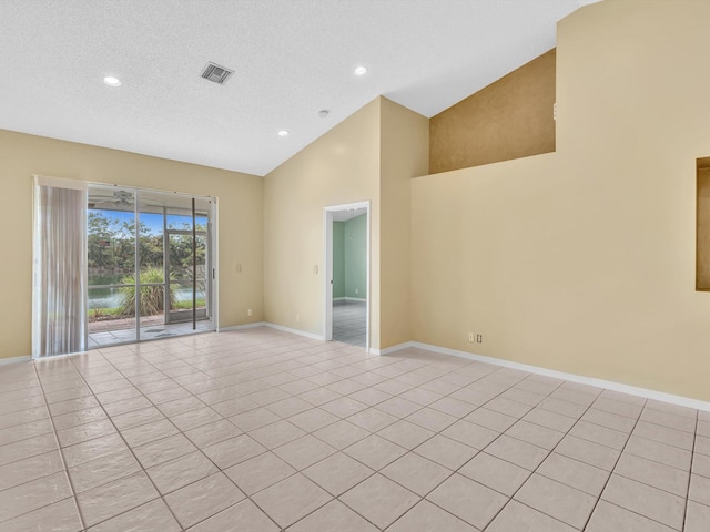 18458 Via Di Sorrento, Boca Raton, FL 33496 - empty room with high vaulted ceiling, light tile patterned flooring, baseboards, recessed lighting, and a textured ceiling