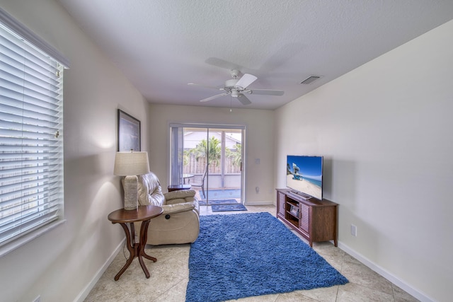188 Wandering Trl, Jupiter, FL 33458 - living area featuring a textured ceiling, a ceiling fan, baseboards, and light tile patterned flooring