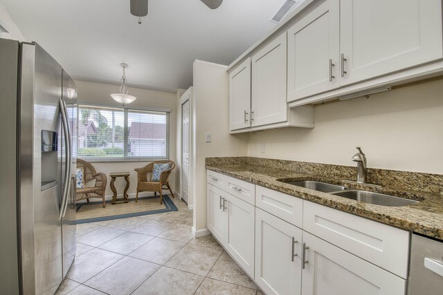 188 Wandering Trl, Jupiter, FL 33458 - kitchen featuring stainless steel fridge, a sink, stone counters, ceiling fan, and white cabinetry