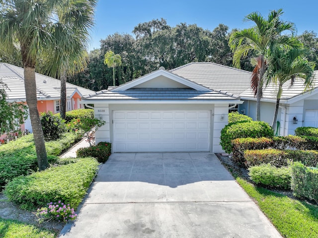 8338 Old Forest Rd, Palm Beach Gardens, FL 33410 - ranch-style house with stucco siding, driveway, an attached garage, and a tiled roof