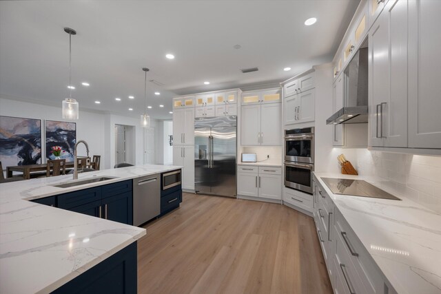 1770 Flagler Manor Cir, West Palm Beach, FL 33411 - kitchen featuring built in appliances, a sink, light wood finished floors, tasteful backsplash, and hanging light fixtures