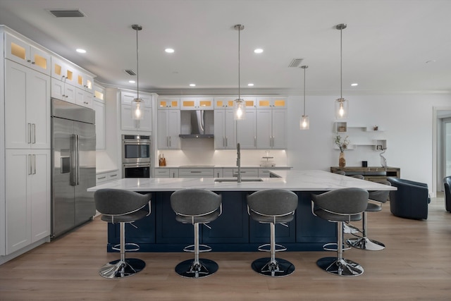 1770 Flagler Manor Cir, West Palm Beach, FL 33411 - kitchen featuring appliances with stainless steel finishes, extractor fan, a sink, light wood-style floors, and white cabinets