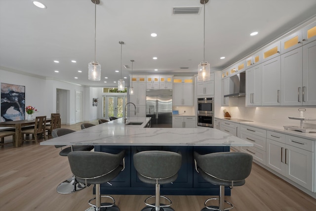1770 Flagler Manor Cir, West Palm Beach, FL 33411 - kitchen featuring stainless steel appliances, wall chimney range hood, light wood-style floors, a sink, and recessed lighting