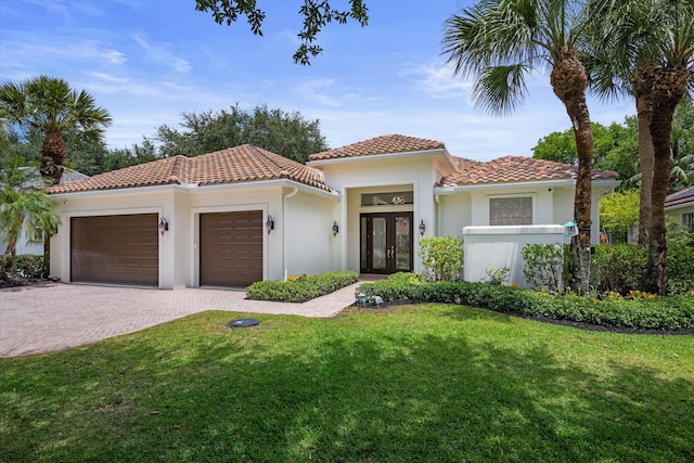 1770 Flagler Manor Cir, West Palm Beach, FL 33411 - mediterranean / spanish house with french doors, an attached garage, a front lawn, decorative driveway, and a tiled roof