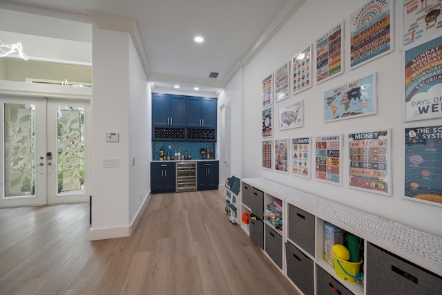 1770 Flagler Manor Cir, West Palm Beach, FL 33411 - indoor wet bar featuring ornamental molding, beverage cooler, light wood-style floors, decorative backsplash, and french doors