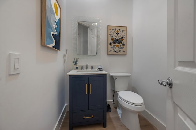 1770 Flagler Manor Cir, West Palm Beach, FL 33411 - half bathroom with baseboards, toilet, vanity, and wood finished floors
